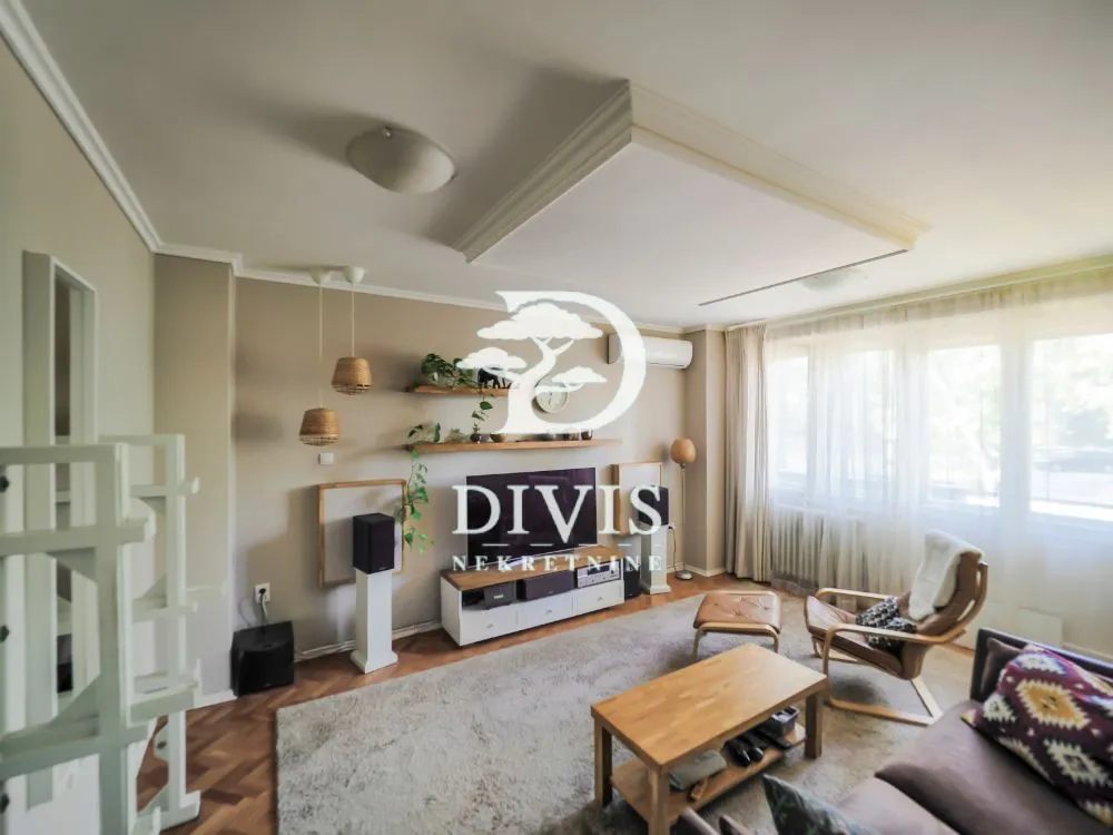 Comfortable living room with a sofa, TV, and wooden coffee table.