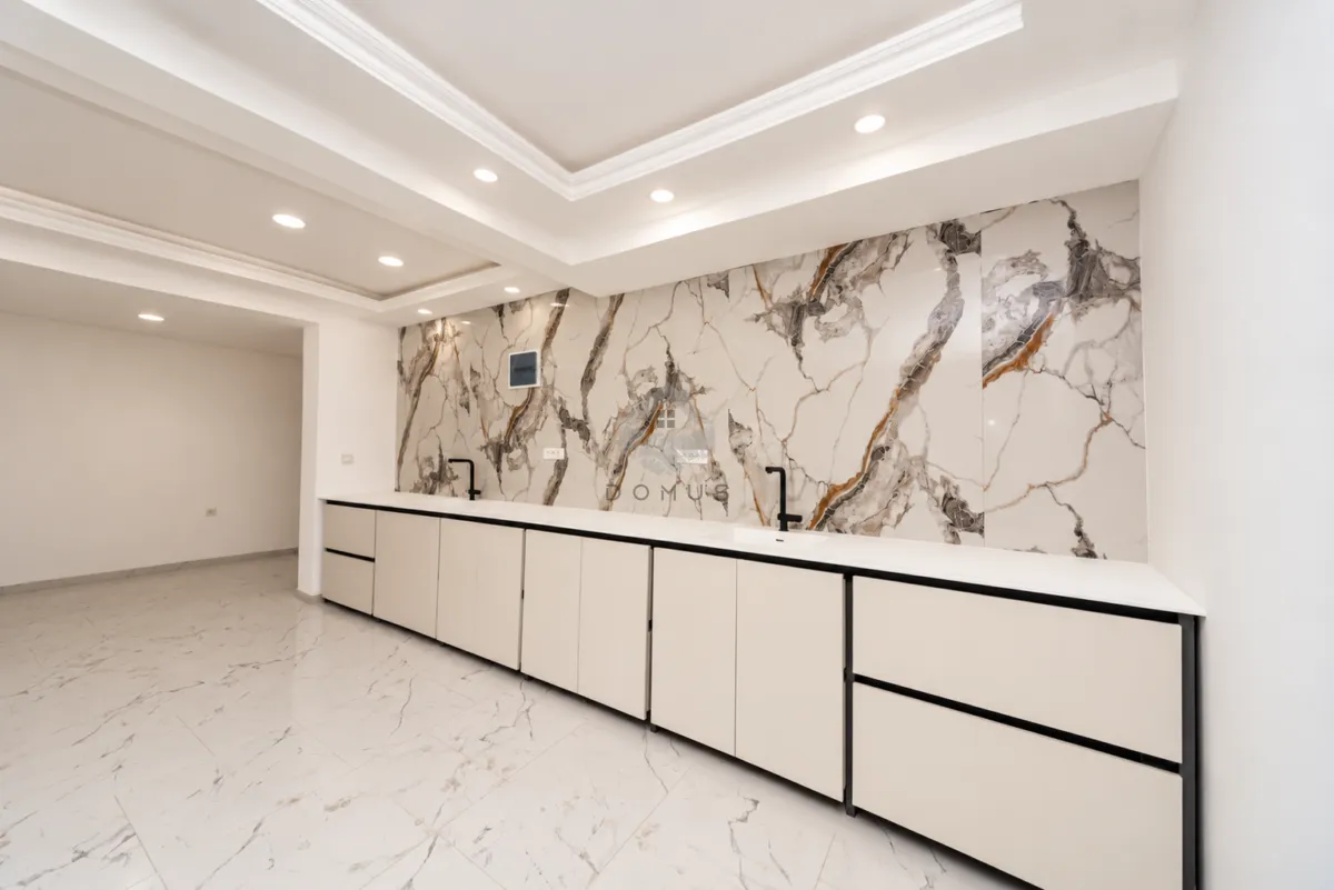 Modern kitchen with a marble backsplash and built-in cabinetry.