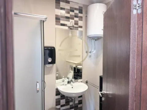 Bathroom equipped with a washbasin, shower cabin, and water heater. - image 11
