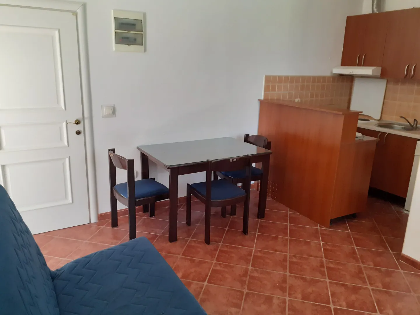 Manja kuhinja sa trpezarijskim stolom i stolicama.
