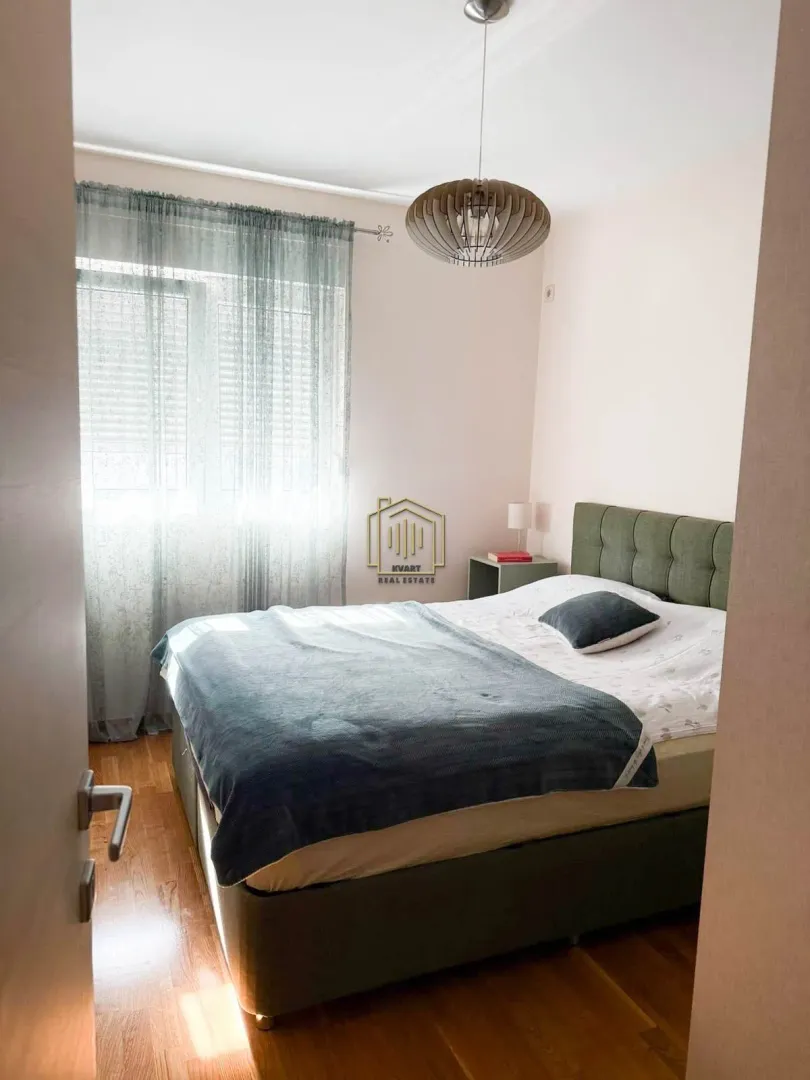 Furnished bedroom with a double bed and a window.