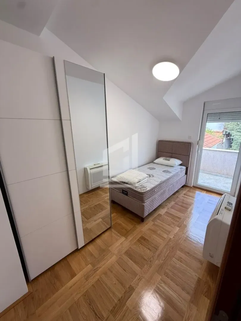 Smaller bedroom with a bed, mirrored wardrobe, and access to the terrace.