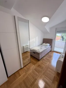 Smaller bedroom with a bed, mirrored wardrobe, and access to the terrace. - image 11