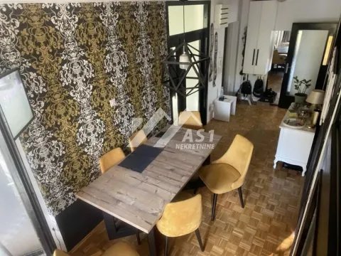 Trpezarija sa drvenim stolom i žutim stolicama uz dekorativni zid. - image 15