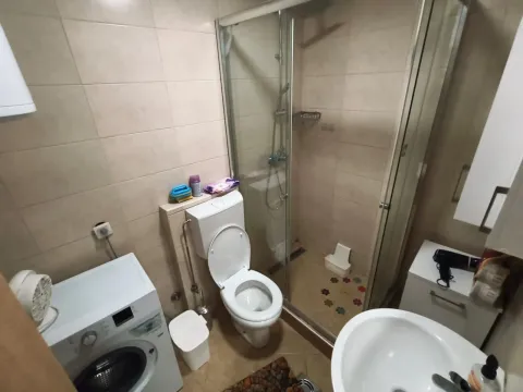 Compact bathroom with a shower cabin, toilet, washbasin, and washing machine. - image 11