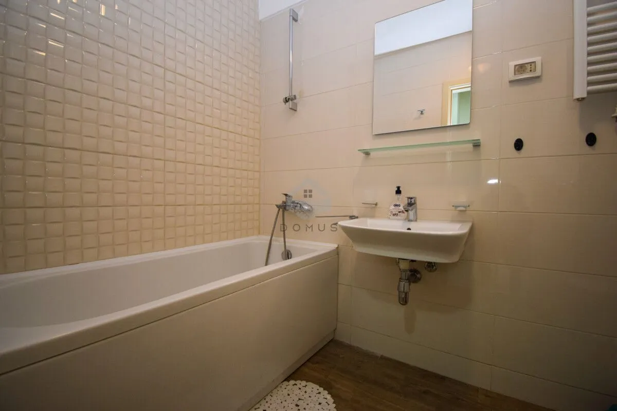 Bathroom equipped with a bathtub, washbasin, and mirror.