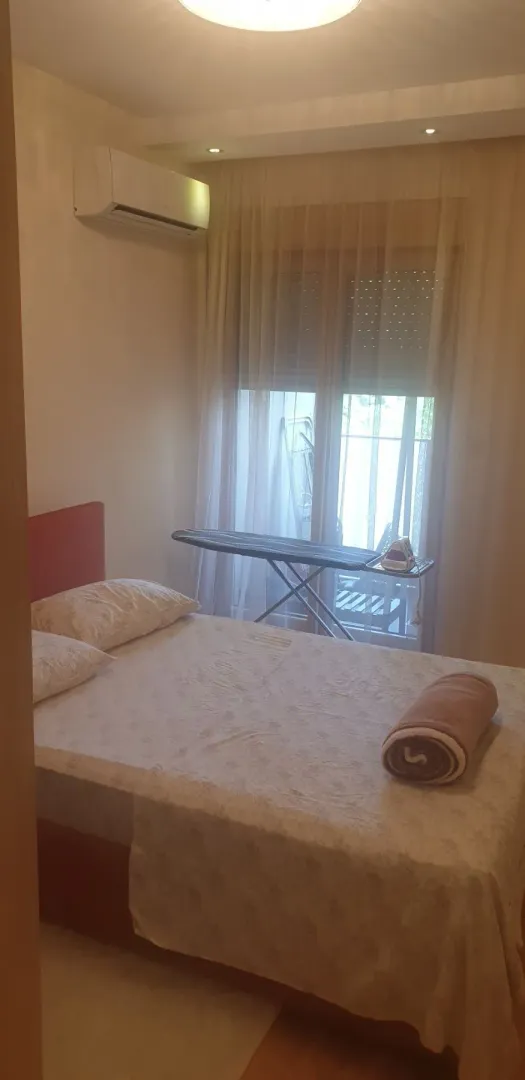 Spavaća soba sa bračnim krevetom i klima uređajem.