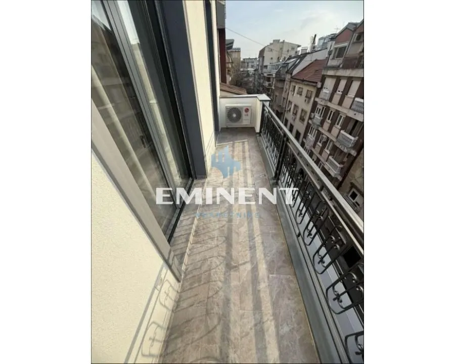 A view of a spacious balcony with a metal railing and an outdoor air conditioning unit.
