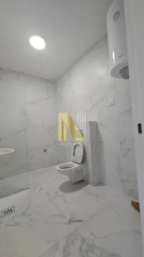 Novoopremljeno kupatilo sa belim mermernim pločicama i ugrađenom sanitarijom. - image 10