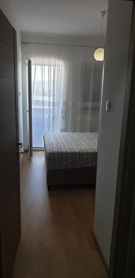 Spavaća soba sa krevetom i izlazom na terasu.