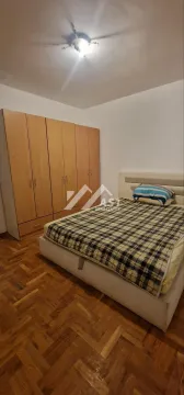 Spavaća soba sa bračnim krevetom i drvenim ormarom. - image 6