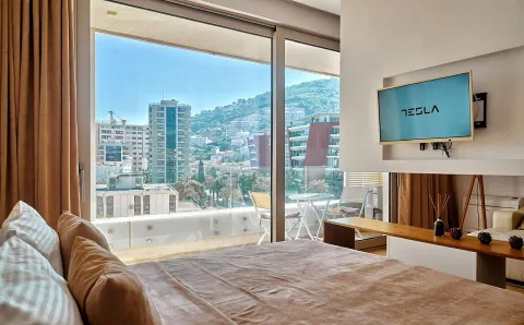Bedroom with a large double bed, a TV, and a city view. - image 3