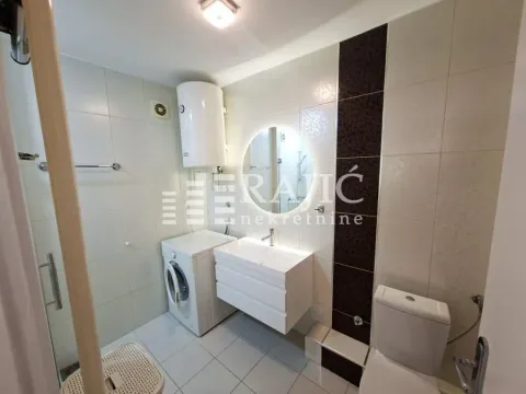 Moderno opremljeno kupatilo sa belim pločicama, umivaonikom i mašinom za veš. - image 9
