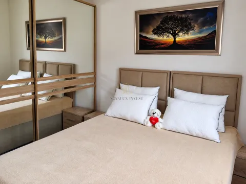 Furnished bedroom with a double bed, white pillows, and a large mirror. - image 10