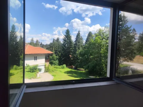 Pogled kroz prozor na zeleno dvorište, stabla i susednu kuću. - image 6