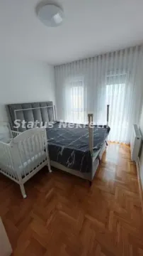 Spavaća soba sa bračnim krevetom, krevetcem i parketom na podu. - image 10
