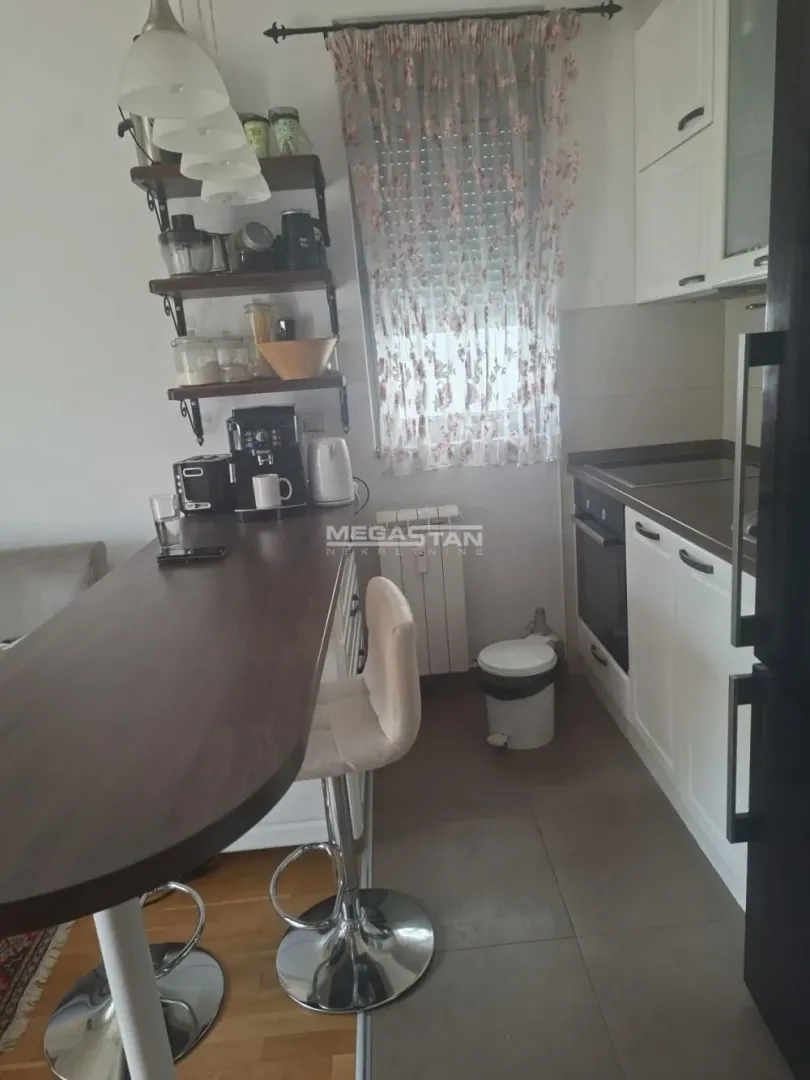 Smaller equipped kitchen with a breakfast bar and bar stools.