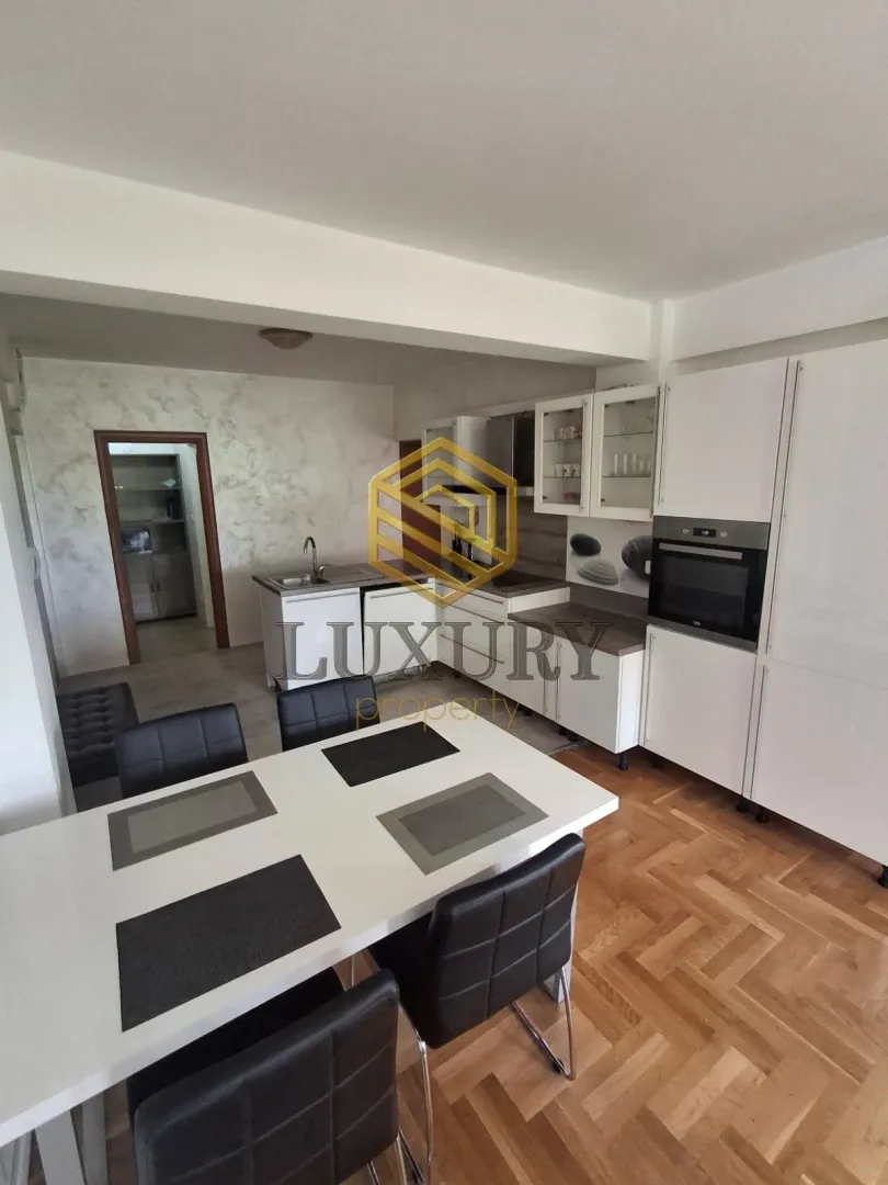 Dining area with kitchen and white cabinetry.