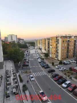 Pogled sa prozora na ulicu sa parkiranim automobilima i okolne stambene zgrade. - image 10