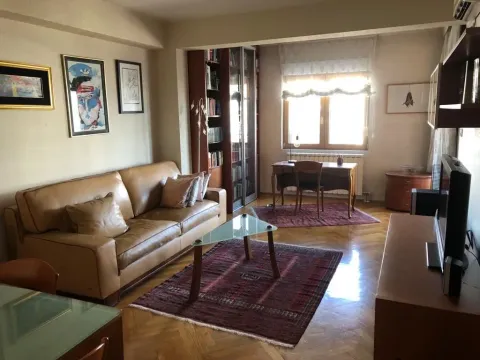 Bright living room featuring a leather sofa, a study desk by the window, and a bookshelf. - image 3