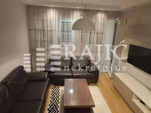 Furnished living room with sofa set and TV.