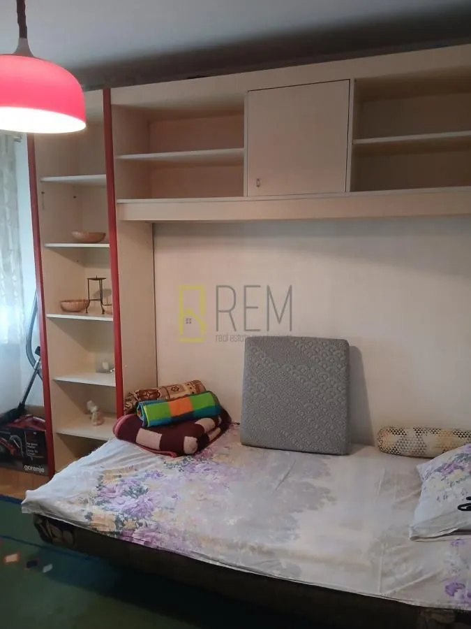 Living or bedroom with a bed and built-in units.
