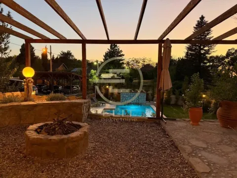 Dvorište sa bazenom, garniturom za sedenje i kaminom pod drvenom pergola konstrukcijom u sumrak. - image 7