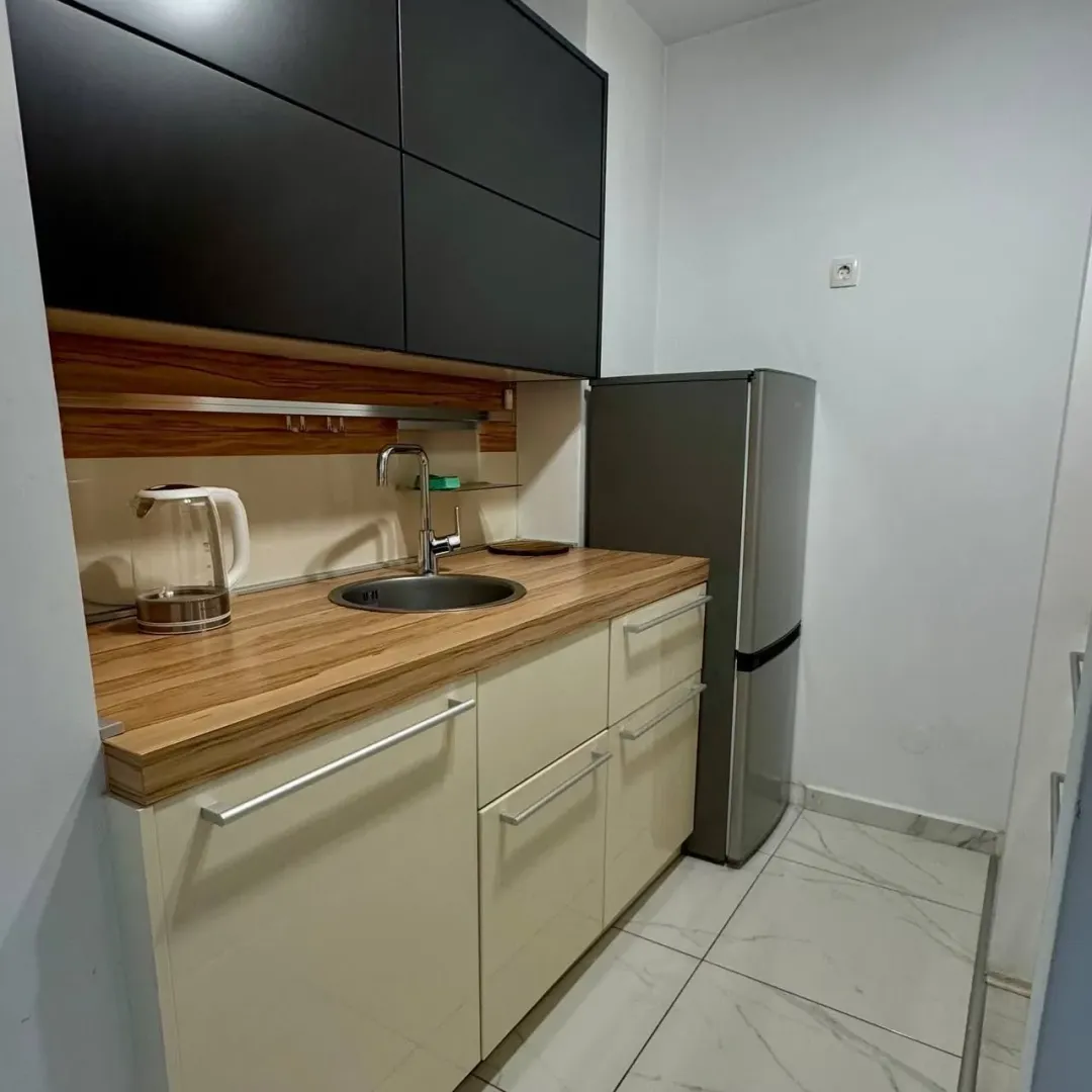 Small kitchen with black and beige cabinets.