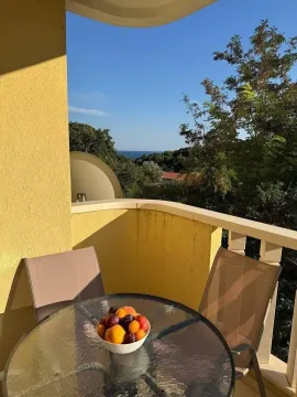 Namještena terasa sa stolom, stolicama i pogledom na more. - image 16