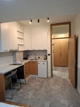 Modern and tidy kitchen with a breakfast bar and built-in units. - image 9