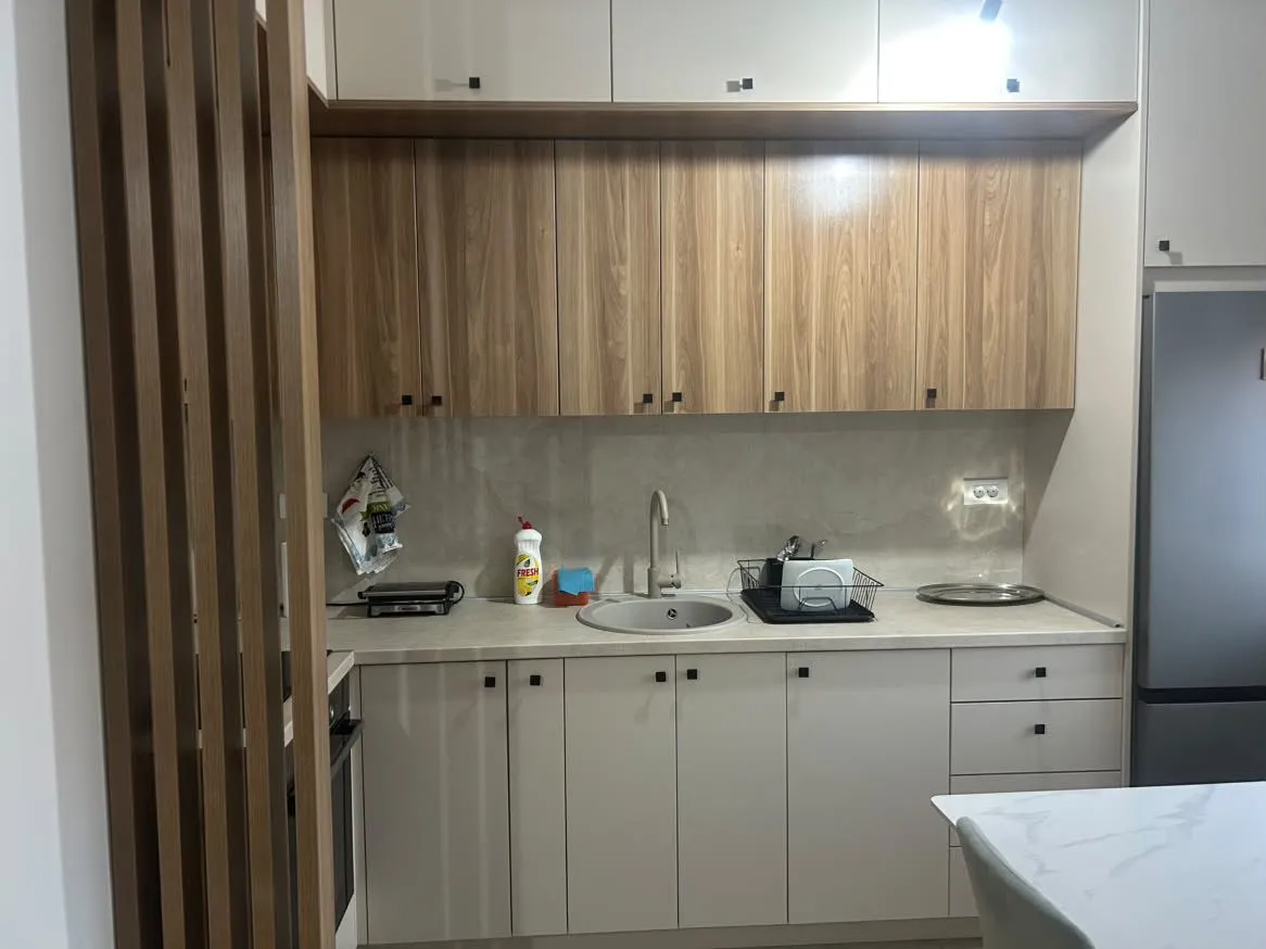 Modern kitchen with wooden cabinets and bright countertops.