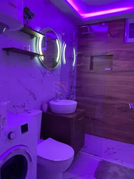 Modernly equipped bathroom with a walk-in shower, washbasin, and washing machine. - image 6
