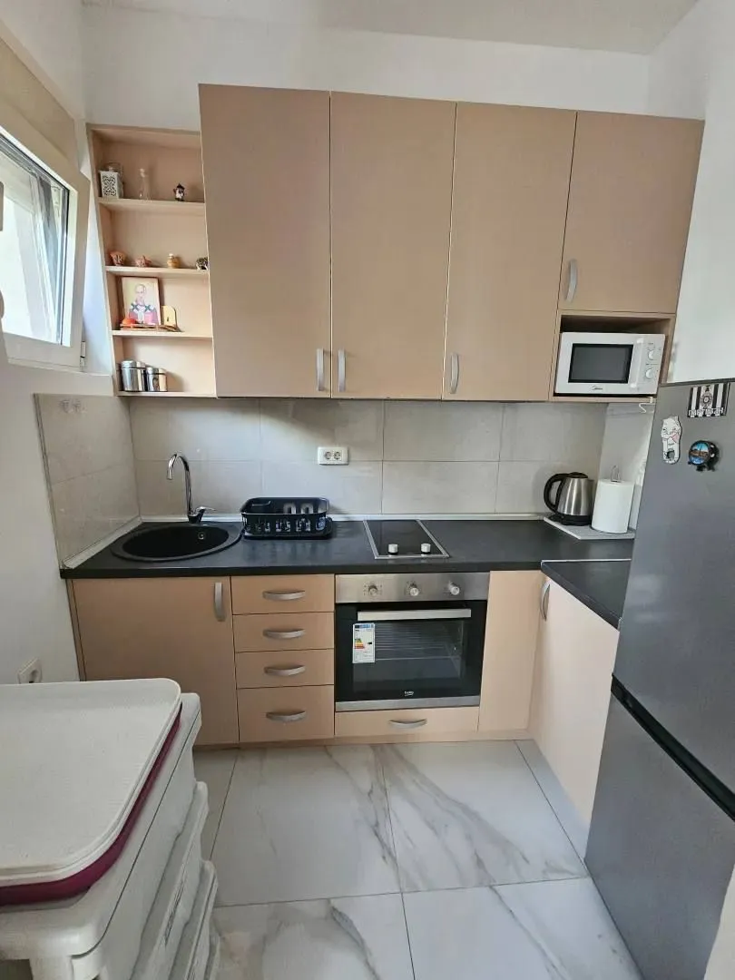 Small kitchen with beige cabinets and built-in appliances.