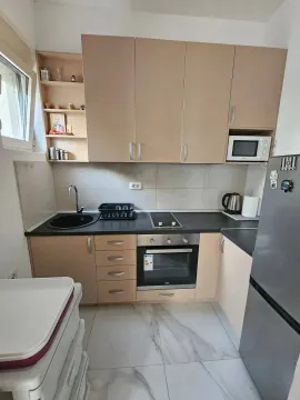 Small kitchen with beige cabinets and built-in appliances. - image 3
