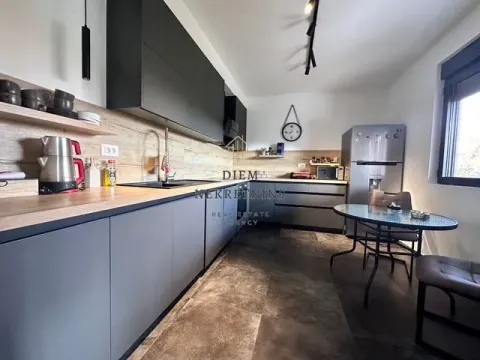 Modern kitchen with a dining table and dark cabinetry. - image 3