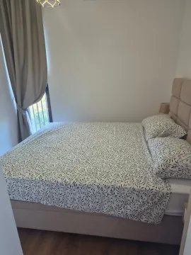 Furnished bedroom with a double bed and a window. - image 11