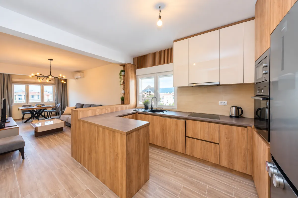Modern open-plan kitchen with wooden cabinetry connected to the dining and living area.