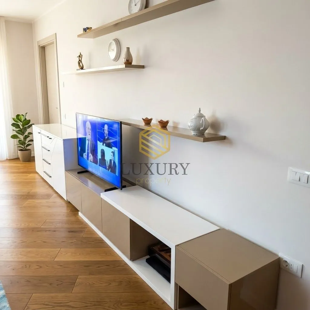 Living room with a TV, console unit, and wall shelves.