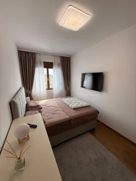 Uređena spavaća soba sa bračnim krevetom, TV-om i prozorom. - image 11