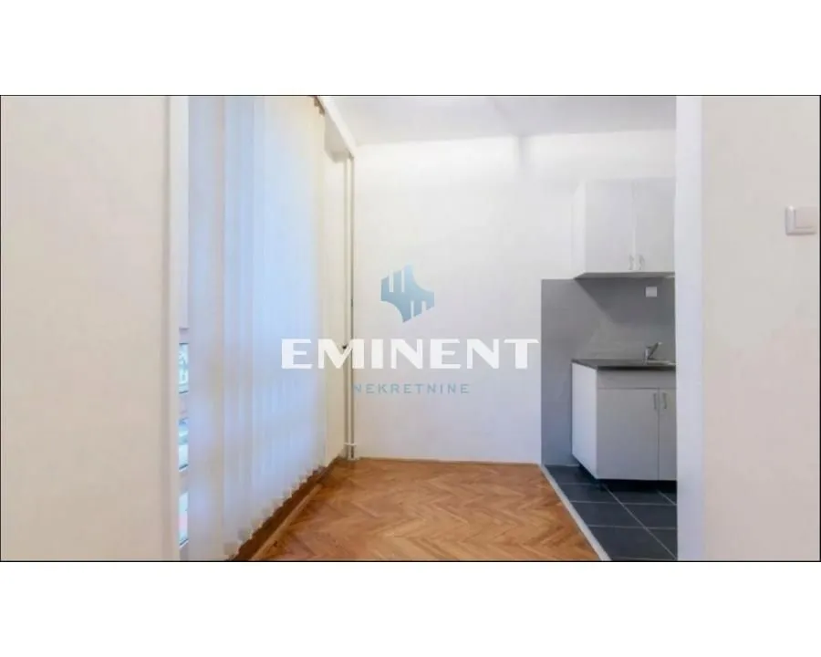 View of a small kitchen with white cabinetry and parquet flooring in the front area.