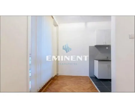 View of a small kitchen with white cabinetry and parquet flooring in the front area. - image 3