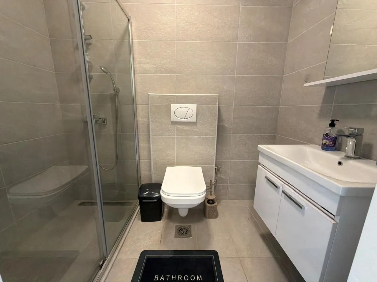 Moderne kupatilo sa tuš kabinom, umivaonikom i toaletom.