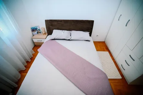 Spavaća soba sa bračnim krevetom, ormarom i drvenim podom. - image 14