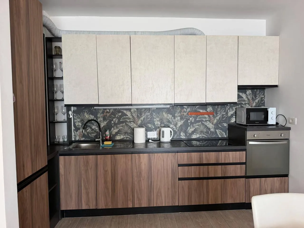 Modern kitchen with wooden elements and built-in appliances.