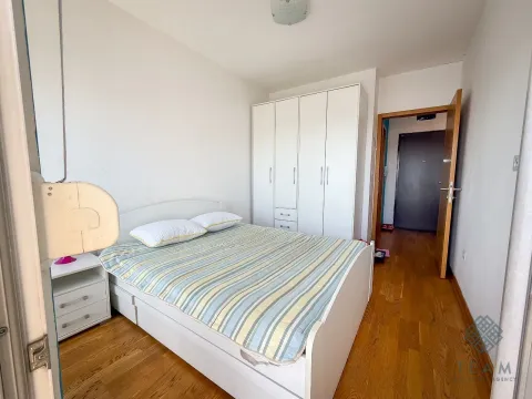 Furnished bedroom with a double bed, white wardrobe, and a bedside table. - image 6