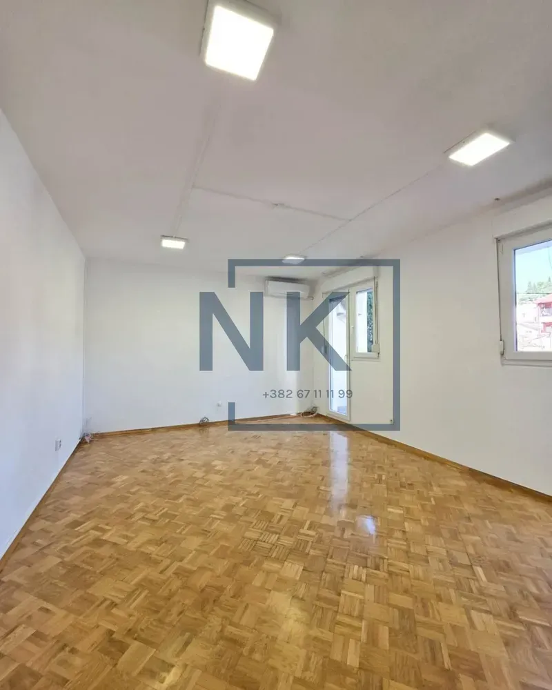 Empty bright room with parquet flooring and white walls.