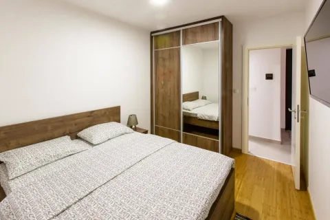 Furnished bedroom with a double bed and a large wardrobe. - image 6