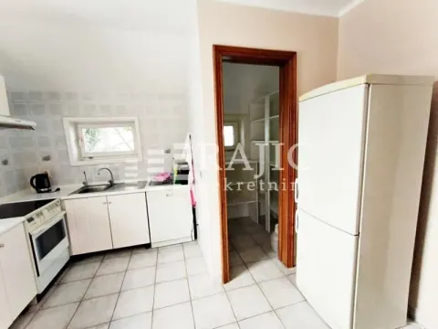 Small bright kitchen with white units and a refrigerator. - image 18
