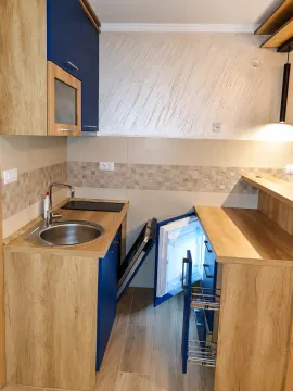 Small kitchen with blue cabinets and a sink. - image 2