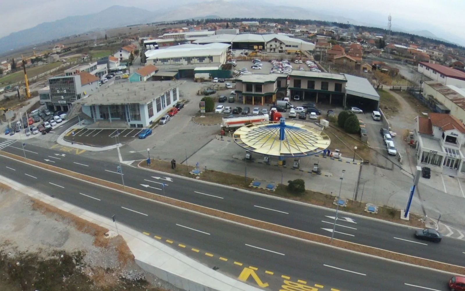Aerial view of a commercial zone with buildings and a gas station.